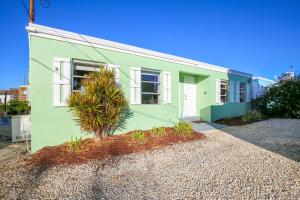 una casa verde con un árbol delante en Fishermans Bungalow Hideaway, en Conch Key