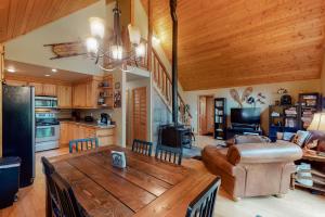 a kitchen and living room with a large wooden table at Tivoli Chalet in Leavenworth