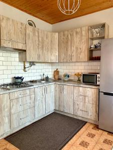 a kitchen with wooden cabinets and a stainless steel refrigerator at Ніч над Карпатами in Slavske