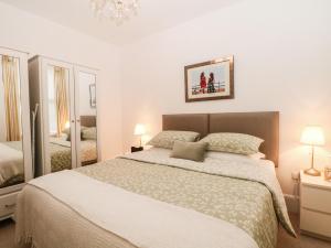 ein Schlafzimmer mit einem großen Bett und einem Spiegel in der Unterkunft 2B Cavendish Villas in Buxton