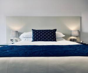 een groot bed met een blauwe deken en 2 lampen bij Dean Park Hotel in Kirkcaldy