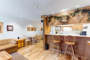 a kitchen and living room with a counter and chairs at Cozy Condo in Ski Trails in Truckee