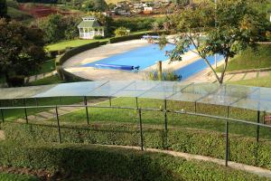 uma vista para uma piscina atrás de uma cerca em Pousada Golden Garden em Caxambu