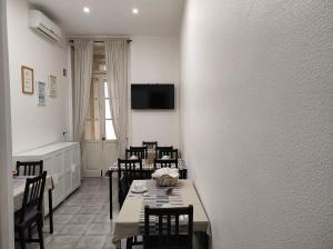 un comedor con mesas, sillas y una pared en Lira Guest House B&B, en Oporto