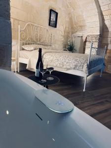a room with a bed and a table with a bottle and glasses at Classe 51 - B&B con Jacuzzi - in Altamura