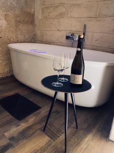 a bottle of wine on a table next to a bath tub at Classe 51 - B&B con Jacuzzi - in Altamura