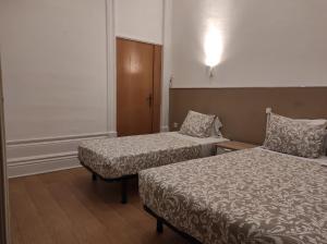 ポルトにあるLira Guest House B&Bのベッド2台とキャビネット付きのホテルルームです。
