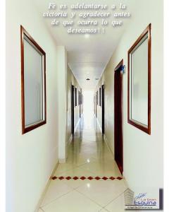 un couloir dans un bâtiment avec une citation sur le mur dans l'établissement Hotel La Gran Esquina, à Puerto Boyacá