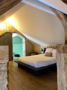 a bedroom with a large bed in an attic at A l'orée de la forêt in Recloses