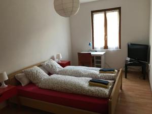 a bedroom with two beds and a desk and a television at Grotto Zendralli in Roveredo