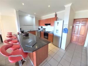 a kitchen with a counter and a refrigerator at Kuta Beach Unit 7 in Margate
