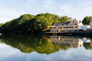 a large house sitting next to a body of water at Mabel's House in Kennebunkport