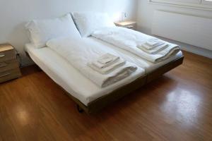 a bed with white sheets and pillows on it at Mayenzett 34 in Leukerbad