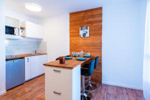 a kitchen with a table with wine glasses on it at Beautiful apartment 8min Disney in Montévrain
