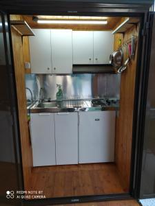 a kitchen with white cabinets and a sink at For Nature Lovers 2 in Skala Rachoniou