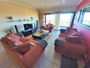 a living room with two couches and a fireplace at Kuta Beach Unit 12 in Margate