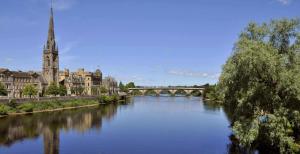 a river in a city with a bridge and buildings at Monart Stylish City Centre Apartment, 2 Bed, sleeps 6 in Perth