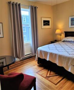 a bedroom with a bed and a large window at Gower Guest House in St. John's