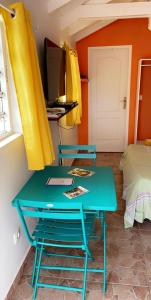 a room with a table and chairs and a bed at Villa Marine in Sainte-Anne