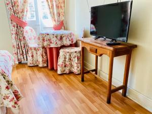 een televisie op een tafel in een kamer bij Hostal Plaza Londres 77 in Santiago