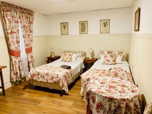 a bedroom with two beds and a window at Hostal Plaza Londres 77 in Santiago +2 photos