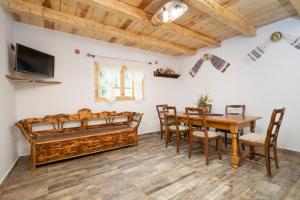 a dining room with a table and chairs and a bed at Casa Bunicilor Apuseni in Geogel