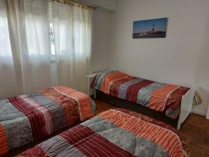 a bedroom with two beds and a picture on the wall at VILLA VIDA - No se aceptan grupos de jóvenes in Mar del Plata