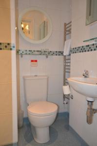 a white toilet sitting next to a sink in a bathroom at Southview Guest House and Indoor Pool in Windermere