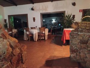 a dining room with tables and chairs and a stone wall at Hotel Rural La Marmita de Ahlam in Fondón