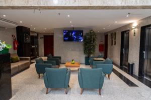 a lobby with chairs and a tv on a wall at Aquidabã Praia Hotel in Fortaleza
