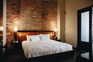 a bedroom with a brick wall and a brick fireplace at Hotel Place D'Armes in Montreal
