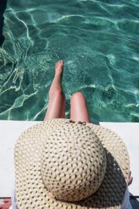 a person with their feet in the water with a hat at Eighteen21 Houses - Casa dos Condes in Cano