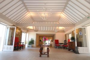Hotel Gudamendi في سان سيباستيان: غرفة كبيرة مع سقف مع إناء من الزهور على طاولة