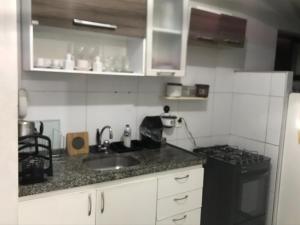 a small kitchen with a sink and a stove at Apartamento grande próximo à praia no calhau in São Luís