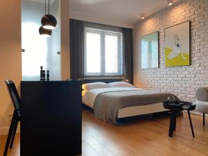 a bedroom with a bed and a brick wall at Apartamenty Modern Gdynia in Gdynia