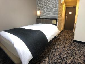- une chambre avec un grand lit dans l'établissement APA Hotel Machidaeki-Higashi, à Machida