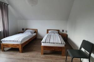 WaldfeuchtにあるFerienwohnung auf dem Dorfのベッドルーム1室(ツインベッド2台、椅子付)