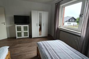 a bedroom with a bed and a large window at Ferienwohnung auf dem Dorf in Waldfeucht