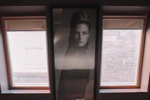 a picture of a woman on a wall next to two windows at Le Monde Hotel in Edinburgh