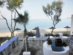 a beach with tables and chairs and the ocean at Thamirakis Studios in Kalyves