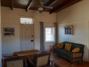 a living room with a green couch and a table at Blye Uitsig in Oudtshoorn