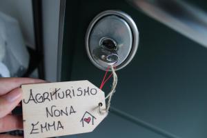 a person holding a sign in front of a door at Agriturismo Nona Emma in Piano Porlezza