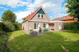 ein Haus mit einem Garten mit grünem Gras in der Unterkunft Vakantiewoning Seaewald in Zeewolde