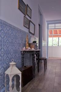Zimmer mit einem Tisch und einer blauen Wand in der Unterkunft Casa da Nonô in Coimbra