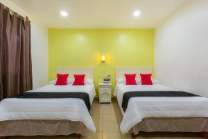 Rúm í herbergi á Capital O Oaxaca Guest Hotel