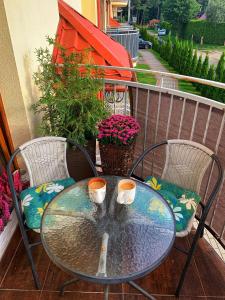 einen Glastisch und Stühle mit zwei Tassen auf dem Balkon in der Unterkunft Apartament Brown Sugar Karwia in Karwia