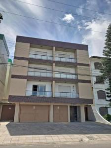 un grande edificio con balcone e due garage di Ap 304 - Beira mar - pés na areia a Capão da Canoa