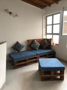 uma sala de estar com um banco e uma janela em Habitación privada en casa de familia cerca del CC VIVA Envigado em Itagüí