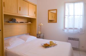 - une chambre avec un lit et un plateau de fruits dans l'établissement Madame Vacances Les Maisons du Lac, à Saint-Jean-de-Monts