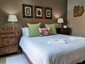 a bedroom with a large white bed and two lamps at Excellent Guest House in Bellville